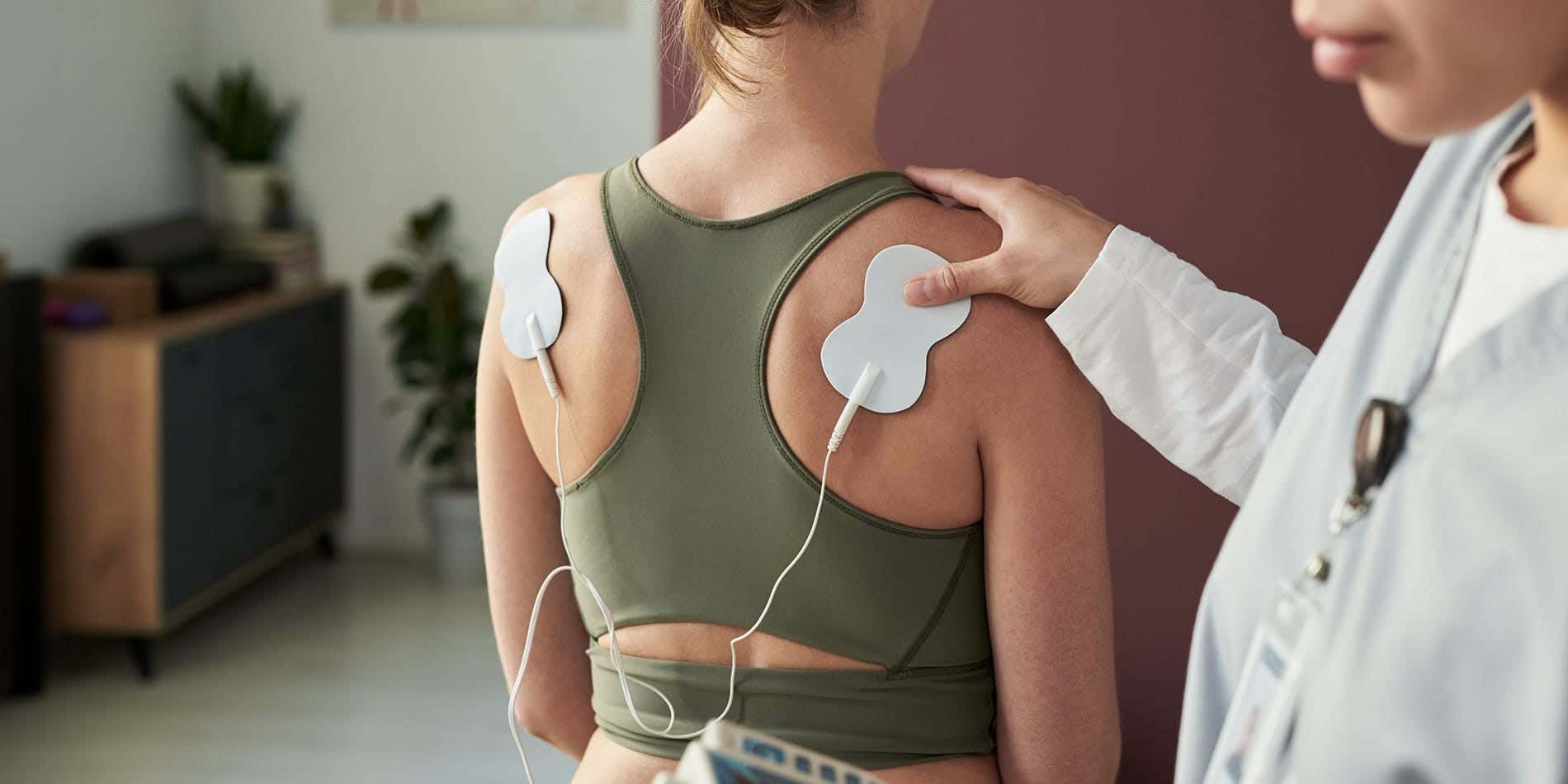 Chiropractor using TENS machine on client